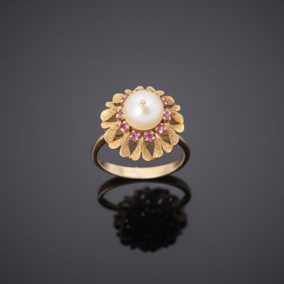 a gold ring with a pearl and ruby stones