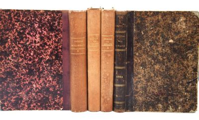 plusieurs vieux livres sont alignés sur une surface blanche