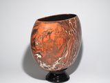a vase that is sitting on a stand on a white surface