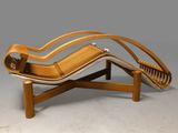 a wooden chaise lounger with a curved seat and wooden legs