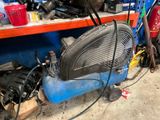 an image of a blue air compressor in a garage