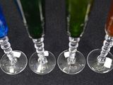 five different colored wine glasses lined up in a row