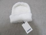 bonnet blanc en tricot avec étiquette, sur tissu gris avec étiquette