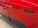 a close up of a red car with a sticker on it
