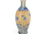 a blue and yellow vase sitting on a white surface