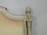 a white bed with a striped headboard and foot board