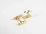 a pair of gold cufflinks on a white background