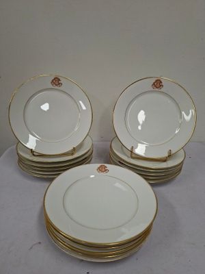 six white plates with gold rims are stacked on top of each other
