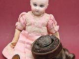 a doll that is sitting on the ground with a basket