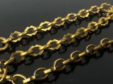 two gold chains are shown on a table with a black background