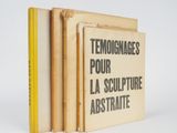 trois livres empilés sur une surface blanche