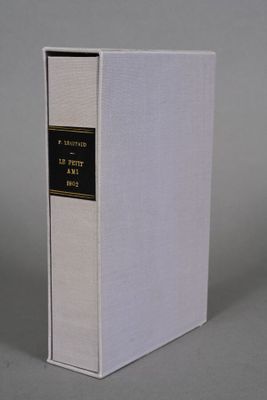 a white book sitting on top of a table next to a gray wall