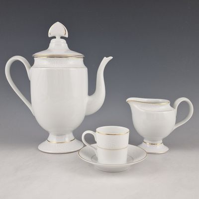 une théière blanche et deux tasses posées sur une table