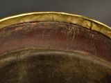 a close up of a metal bowl with a gold rim