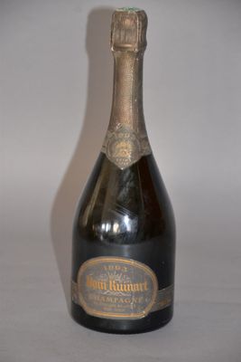 an old bottle of champagne sitting on top of a white table
