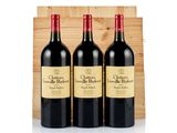three bottles of red wine sit in front of a wooden crate