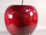 a red apple that is sitting on a white surface