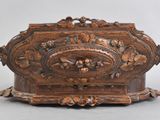 an old wooden box with carvings on it on a gray surface