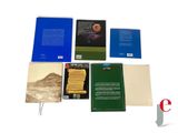 several books are sitting on a white surface next to each other