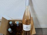 bottles of wine in a cardboard box sitting on the floor