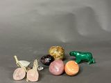 three small figurines of different shapes and sizes sitting on a table