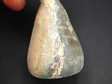 someone is holding a piece of stone in their hand on a black surface