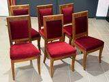 four chairs with red velvet upholstered seats sit on a tile floor