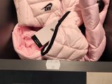 a baby in a pink jacket that is in a stroller