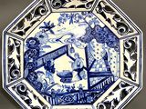 a blue and white plate with a picture of a woman on it