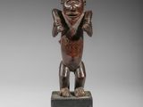 une image représentant une statue en bois d'un singe posée sur un socle