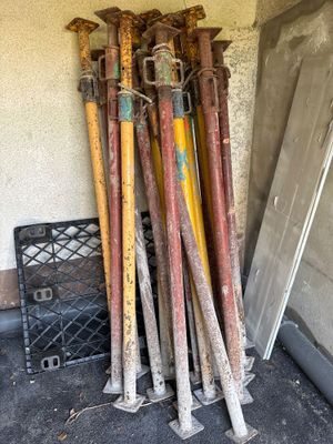 a lot of baseball bats that are leaning up against a wall