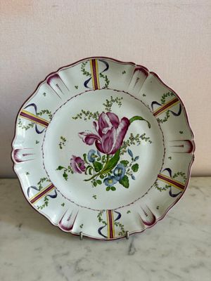 une assiette ornée d'une fleur, posée sur une table
