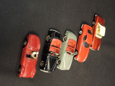 several toy cars are lined up in a row on a black surface