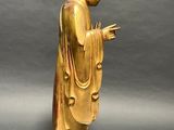 gold statue of a man with a robe and a hat
