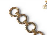 a picture of a gold bracelet with pearls on it