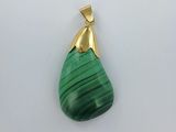 un gros plan d'un pendentif vert sur une surface blanche