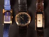 several different watches are lined up in a row on a black surface
