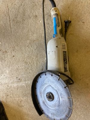 a small circular grinder sitting on the floor next to a small circular grinder