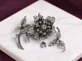 un plateau en marbre blanc orné d'une broche en forme de fleur