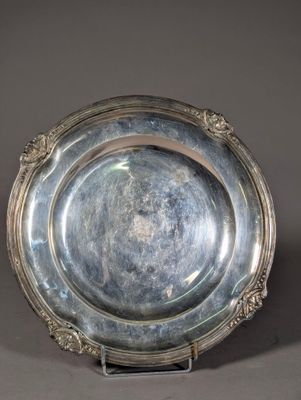 an antique silver plate on a stand on a gray background