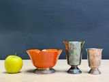 three vases and an apple sitting on a table