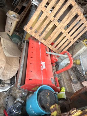 a pile of junk in a garage with a red fire hydrant next to it