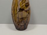 a brown and black vase sitting on a white table