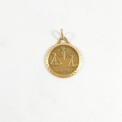 une image représentant un pendentif en or orné d'un signe du zodiaque