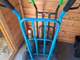 a blue hand truck with two green handles and a black handle