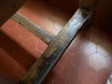 a close up of a wooden chair on a tiled floor
