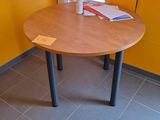 une petite table sur laquelle est posé un livre, dans une pièce jaune