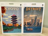 two posters of a city and a boat on the water
