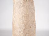 an image of a stone object on a stand on a white surface