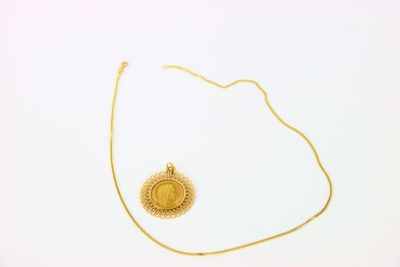 collier plaqué or avec un pendentif en forme de rayons de soleil sur fond blanc